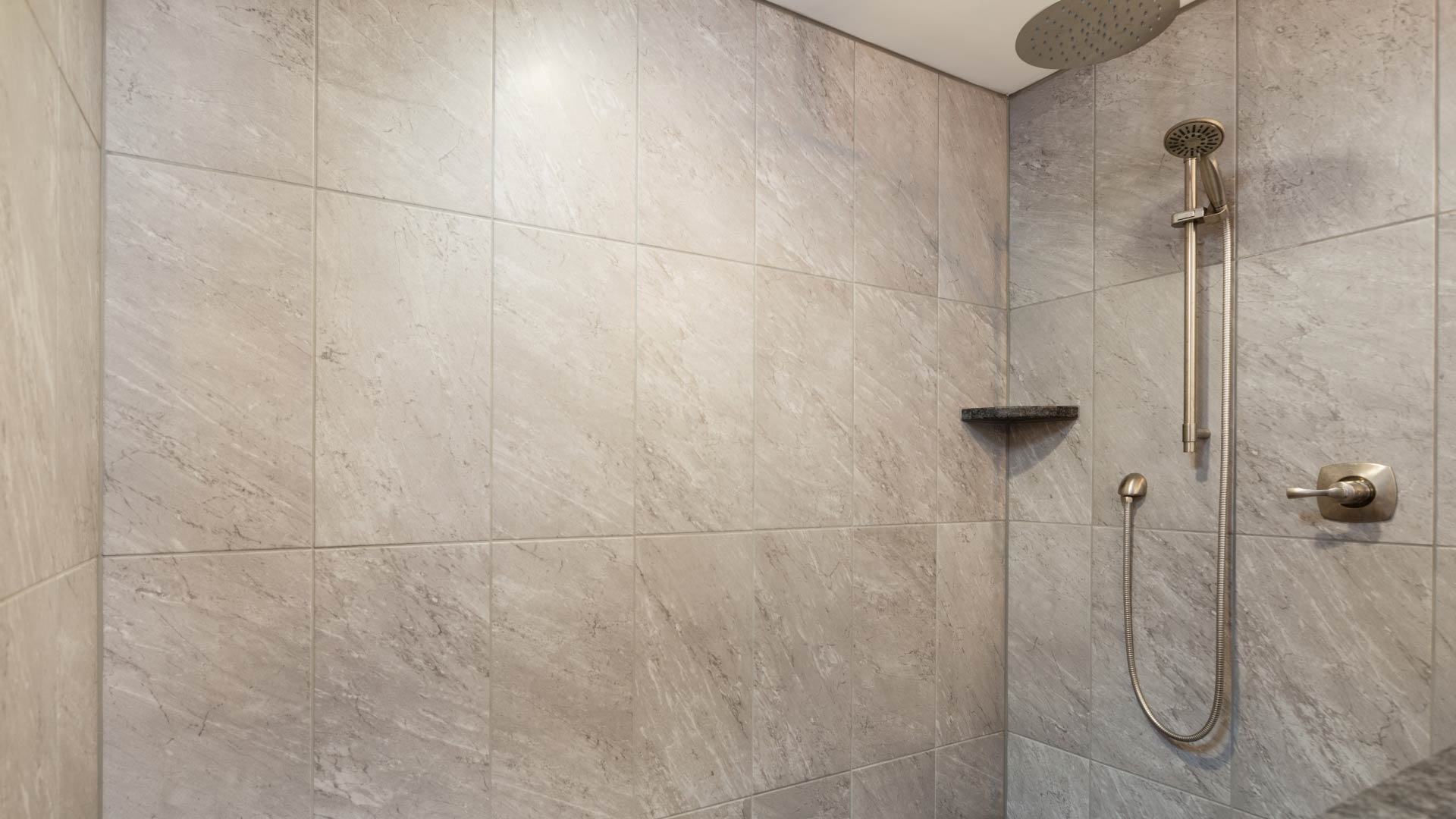 A luxury stand up grey marble shower with a rain shower head with